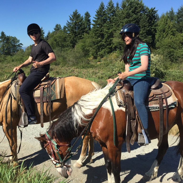 Lady riding horse on trail in Vancouver